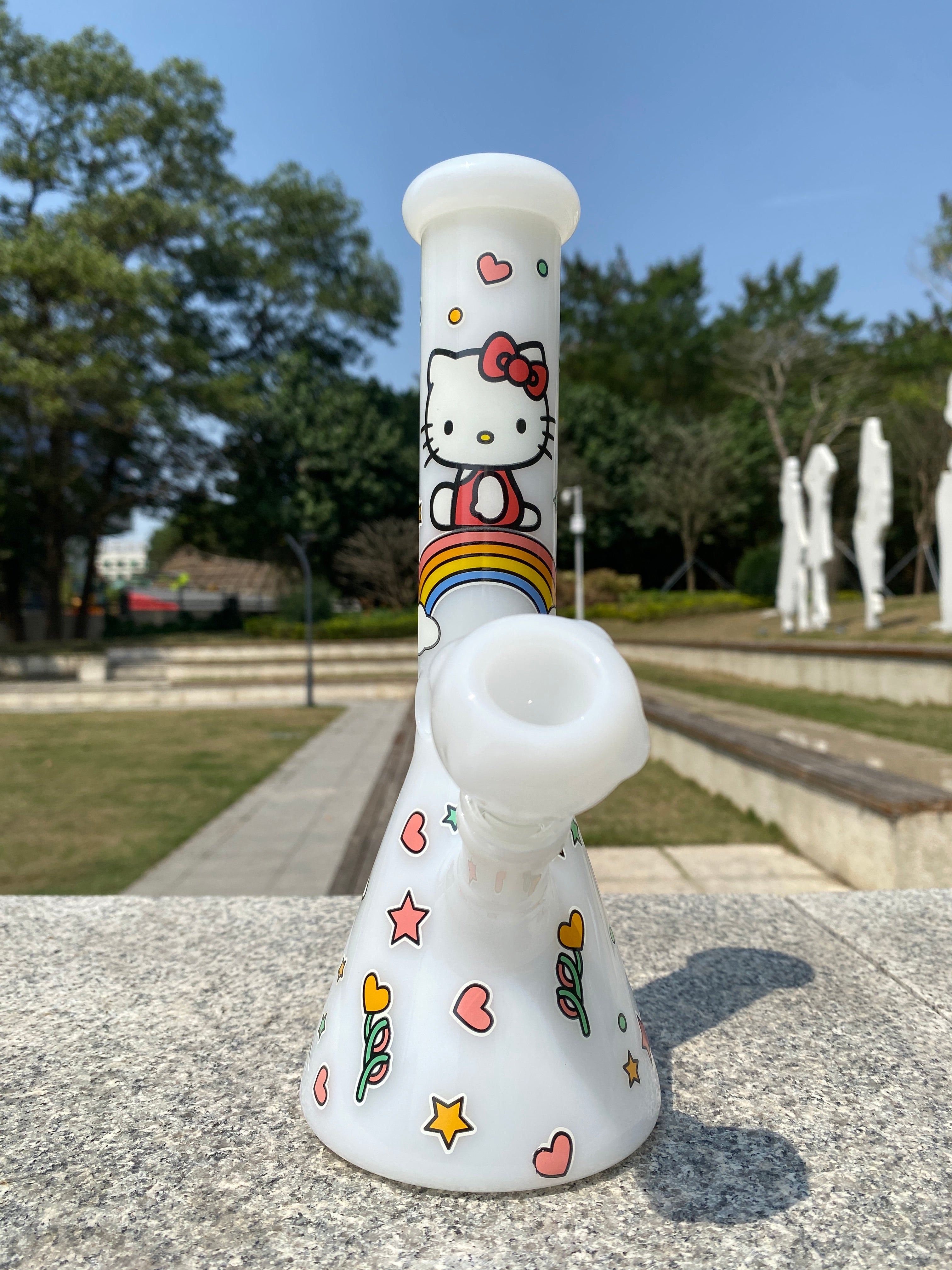 White beaker bong featuring a cute design by Croia Glass with Hello Kitty accents and a smooth, glossy finish.